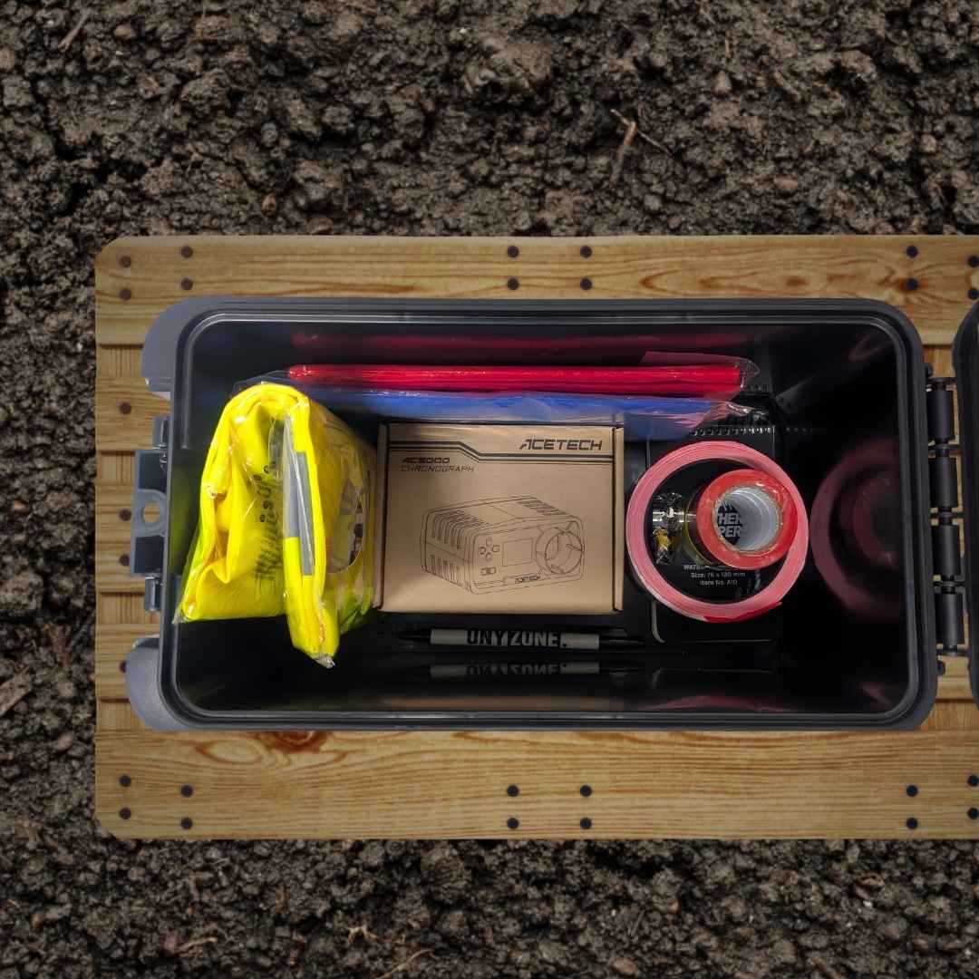 UNYZONE : FOT, Caisse de munition polymère noir pour cal.50 ou pour boîte de rangement étanche en 30 x 16 x 17.5 cm, mise en situation vue de dedans, contenant de l'équipement pour les associations (gilet jaune fluo, drapeaux de jeu, chronographe, ruban de signalisation, sifflet, carnet tout temps, stylo)